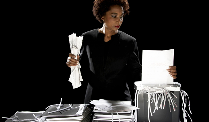 Image showing a woman shredding papers with shredder machine